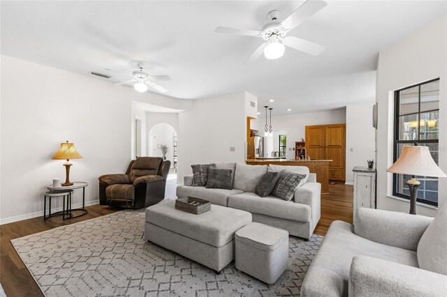 1118 SW 112th St, Gainesville, FL 32607 - living room with wood finished floors, baseboards, a ceiling fan, visible vents, and arched walkways