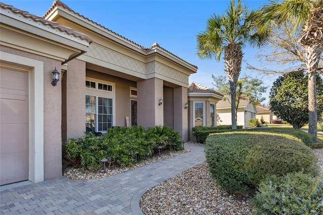 property entrance with a tiled roof and stucco siding