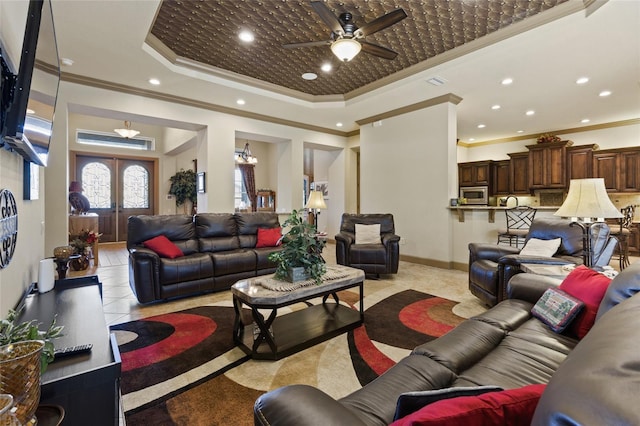living room with a tray ceiling, recessed lighting, a ceiling fan, and ornamental molding