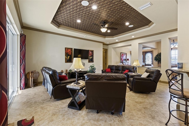 living area with visible vents, crown molding, ceiling fan, light tile patterned flooring, and a raised ceiling