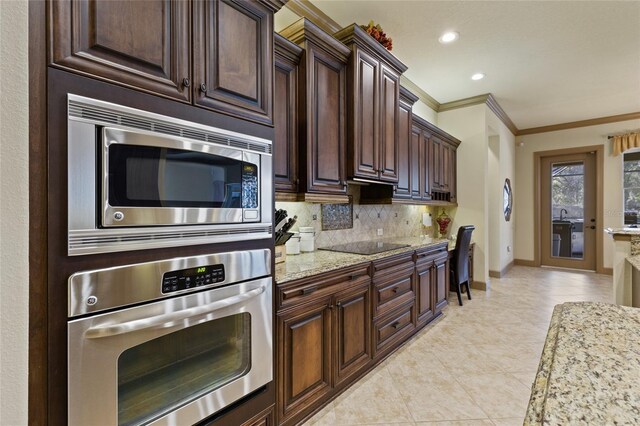 kitchen with light tile patterned floors, baseboards, stainless steel appliances, crown molding, and backsplash