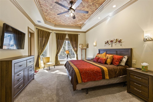bedroom featuring visible vents, ceiling fan, light colored carpet, a tray ceiling, and ornamental molding