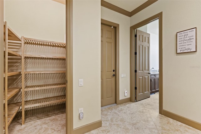 corridor featuring baseboards, light tile patterned flooring, and crown molding