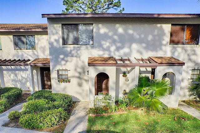 townhome / multi-family property featuring a pergola and stucco siding