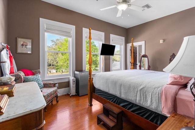 bedroom featuring visible vents, baseboards, and wood finished floors