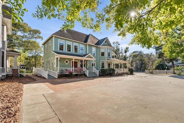 victorian-style house with a porch and concrete driveway