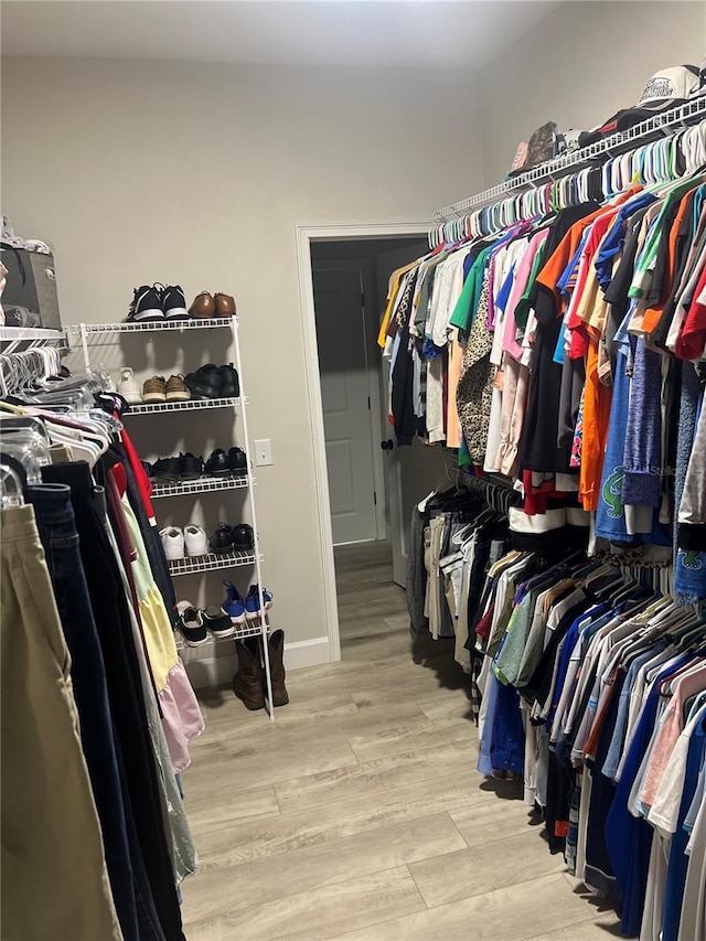 walk in closet with wood finished floors