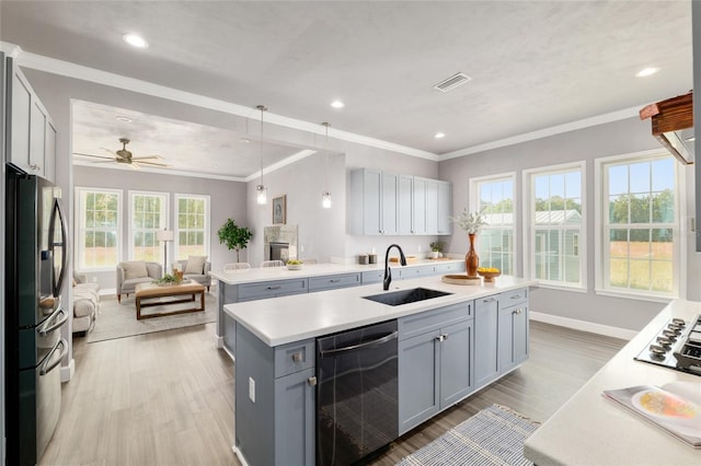 kitchen with visible vents, appliances with stainless steel finishes, a sink, open floor plan, and gray cabinetry
