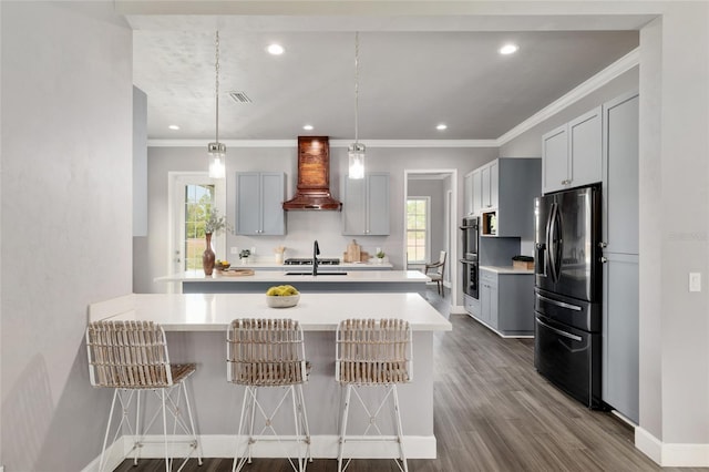 kitchen featuring light countertops, a kitchen bar, custom range hood, refrigerator with ice dispenser, and a peninsula