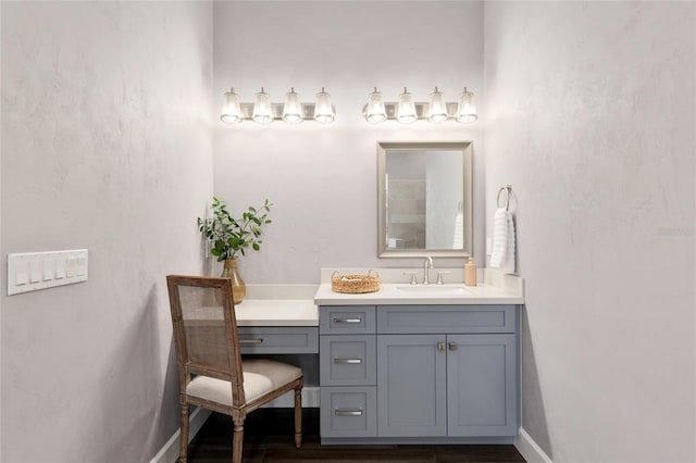 bathroom with baseboards, wood finished floors, and vanity