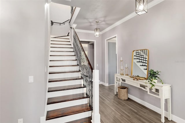 stairway with ornamental molding, baseboards, and wood finished floors