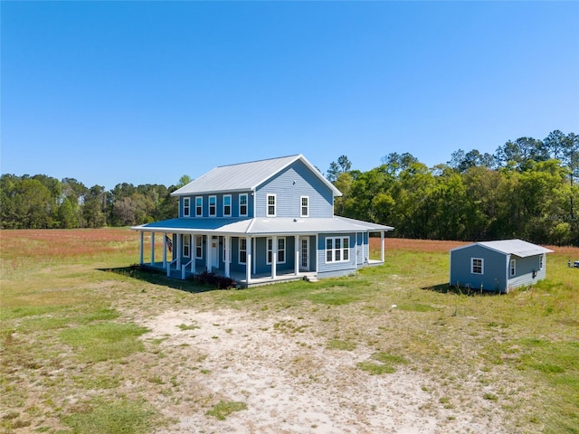 rear view of house featuring a porch and metal roof