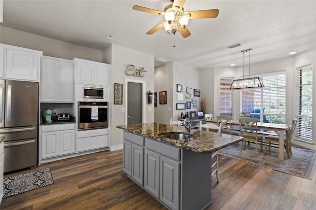 kitchen with dark wood-style flooring, visible vents, a sink, and stainless steel appliances