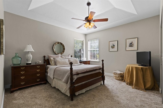 bedroom featuring baseboards, a ceiling fan, carpet flooring, and a raised ceiling