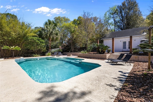 view of pool with a patio area, french doors, a fenced in pool, an outbuilding, and a fenced backyard
