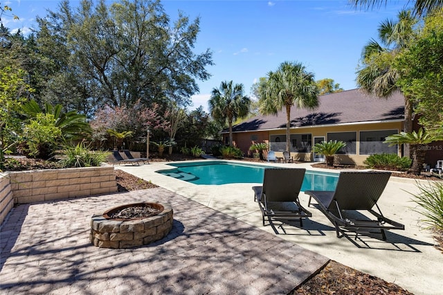 pool featuring an outdoor fire pit and a patio area