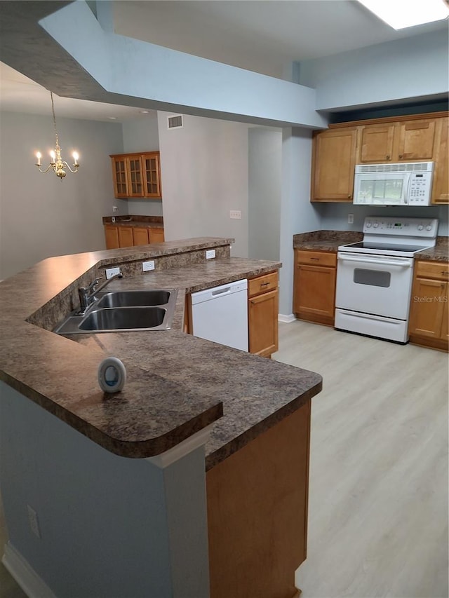2966 NW 105th Dr, Gainesville, FL 32606 - kitchen featuring white appliances, a sink, dark countertops, light wood-type flooring, and a spacious island