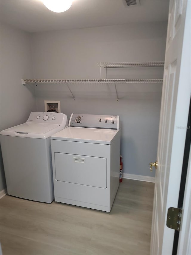 2966 NW 105th Dr, Gainesville, FL 32606 - washroom featuring independent washer and dryer, baseboards, and light wood-type flooring