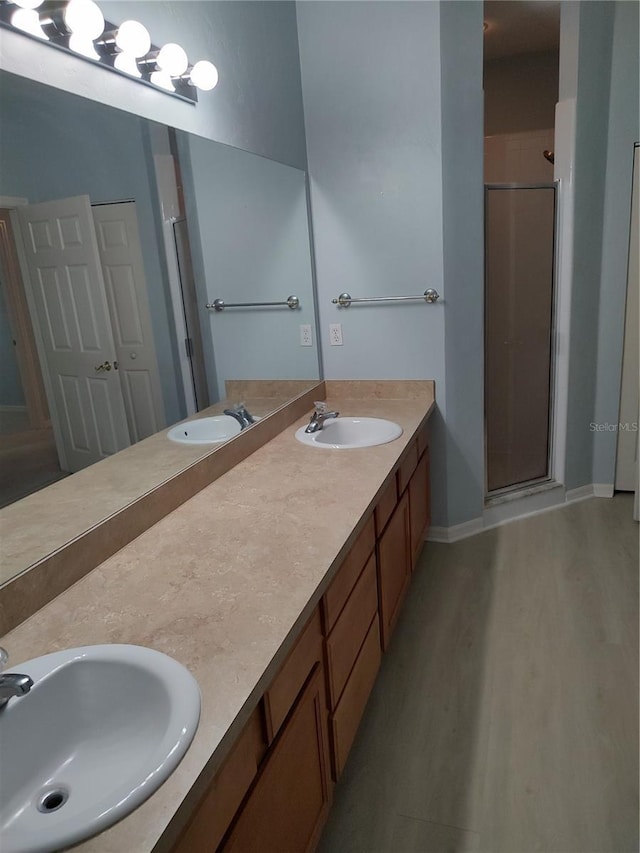 2966 NW 105th Dr, Gainesville, FL 32606 - full bath featuring double vanity, a stall shower, wood finished floors, and baseboards