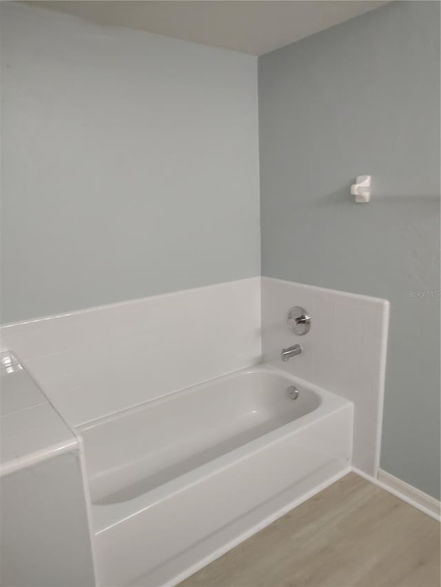 2966 NW 105th Dr, Gainesville, FL 32606 - bathroom featuring a garden tub, wood finished floors, and baseboards