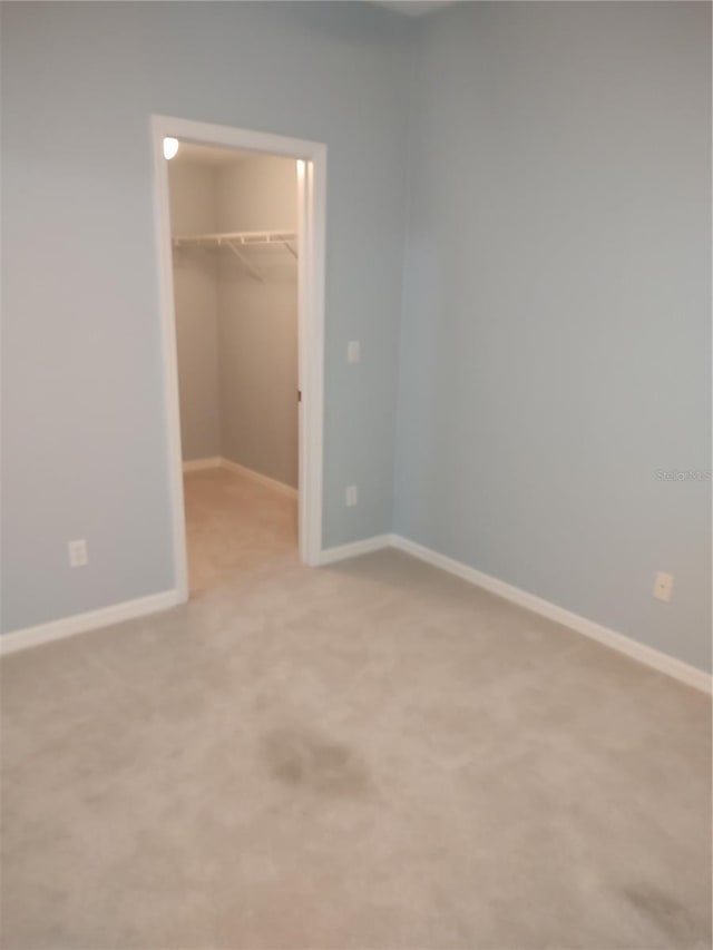 2966 NW 105th Dr, Gainesville, FL 32606 - unfurnished bedroom with a walk in closet, a closet, light carpet, and baseboards