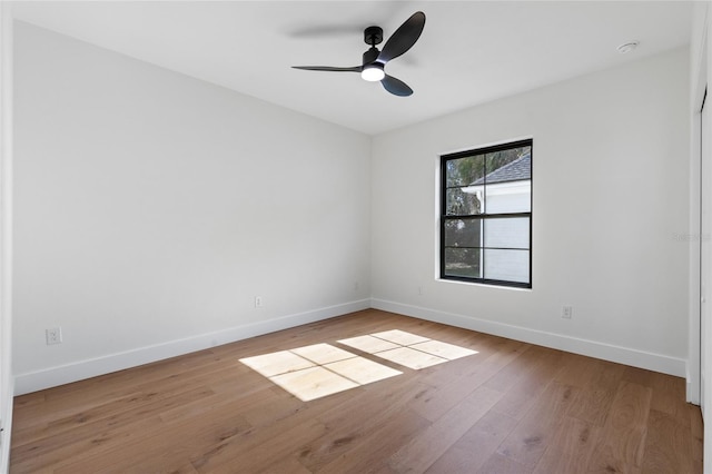 empty room with baseboards, a ceiling fan, and wood finished floors