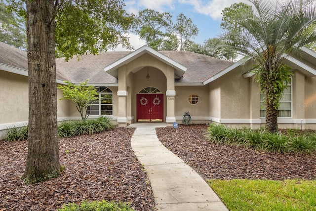 5620 NW 45th Ln, Gainesville, FL 32606 - view of exterior entry featuring stucco siding and roof with shingles