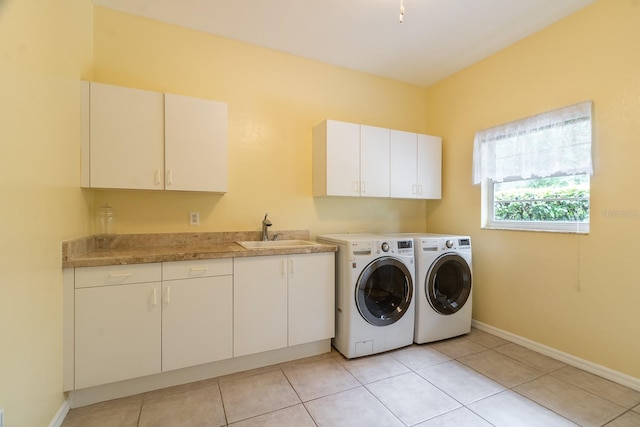 5620 NW 45th Ln, Gainesville, FL 32606 - washroom with baseboards, a sink, cabinet space, separate washer and dryer, and light tile patterned floors