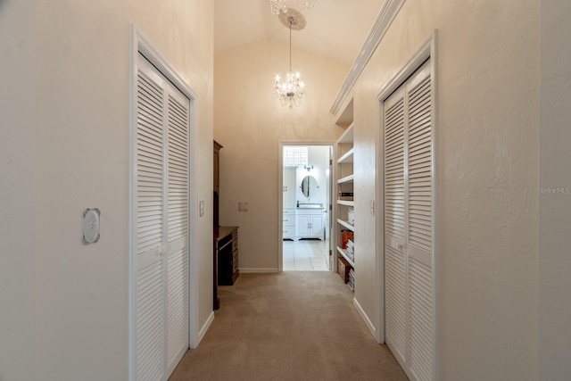 5620 NW 45th Ln, Gainesville, FL 32606 - hall featuring a notable chandelier, high vaulted ceiling, a sink, light carpet, and baseboards