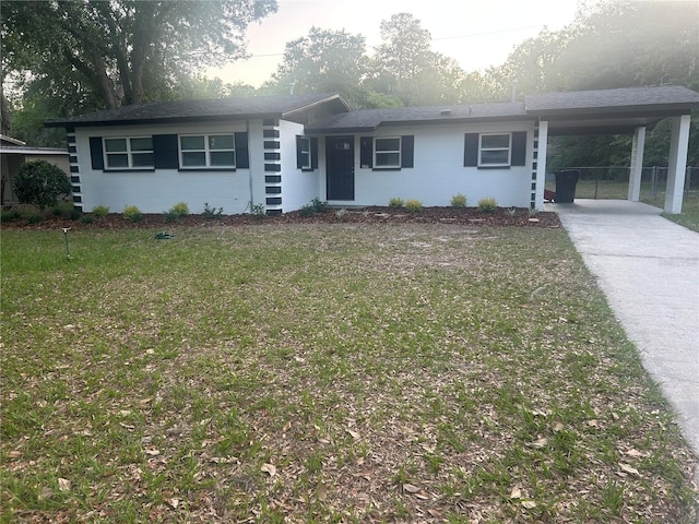 3810 NE 12th St, Gainesville, FL 32609 - ranch-style home with concrete driveway, a front yard, and an attached carport