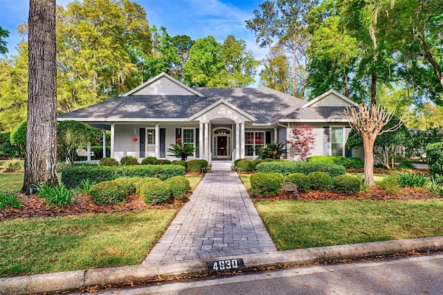 4630 SW 95th Ter, Gainesville, FL 32608 - view of front of home with covered porch, a shingled roof, and a front lawn