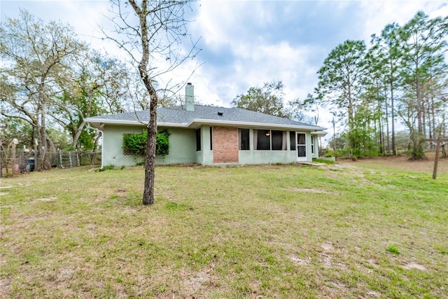 6550 SE 123rd Ter, Morriston, FL 32668 - rear view of property featuring a sunroom, fence, a chimney, stucco siding, and a yard