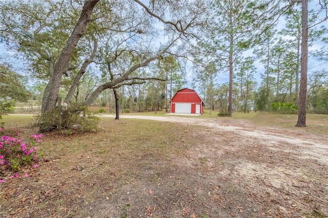 6550 SE 123rd Ter, Morriston, FL 32668 - view of yard with dirt driveway, an outbuilding, a garage, and a barn