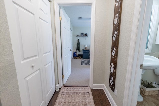 6550 SE 123rd Ter, Morriston, FL 32668 - corridor featuring baseboards, visible vents, a textured wall, and dark wood-style flooring