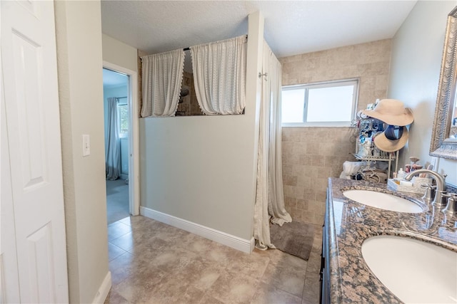 6550 SE 123rd Ter, Morriston, FL 32668 - full bath featuring baseboards, double vanity, a textured ceiling, and a sink