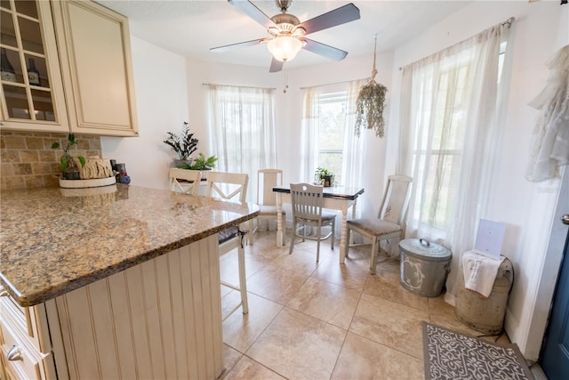 6550 SE 123rd Ter, Morriston, FL 32668 - kitchen with ceiling fan, tasteful backsplash, a breakfast bar, and cream cabinets