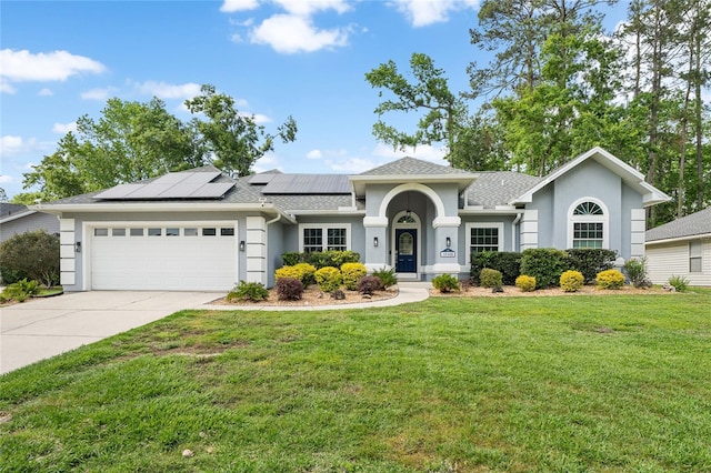 view of front of home with a front yard, stucco siding, an attached garage, and solar panels
