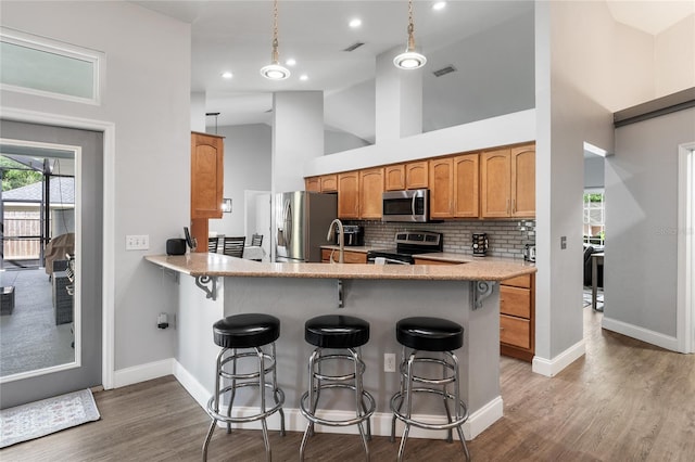 kitchen with decorative backsplash, a breakfast bar, visible vents, and stainless steel appliances