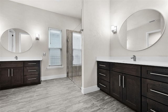 bathroom with a stall shower, a sink, two vanities, baseboards, and visible vents