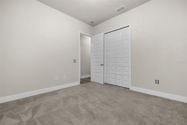 unfurnished bedroom featuring baseboards, carpet floors, and visible vents