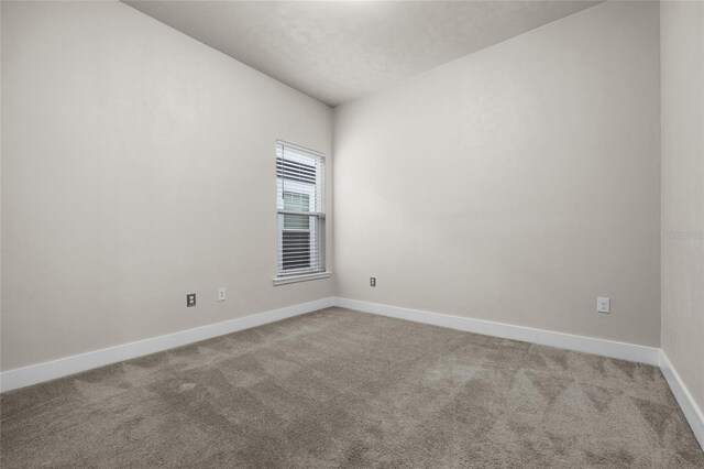 empty room featuring baseboards and carpet floors