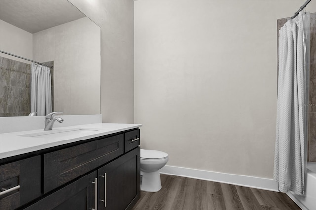 bathroom featuring toilet, wood finished floors, baseboards, and vanity
