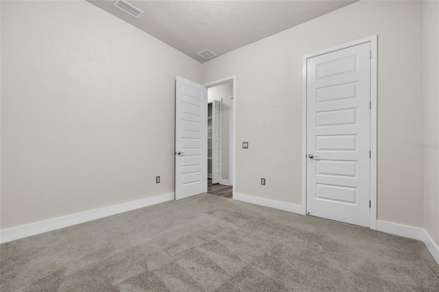 unfurnished bedroom with carpet flooring, baseboards, and visible vents