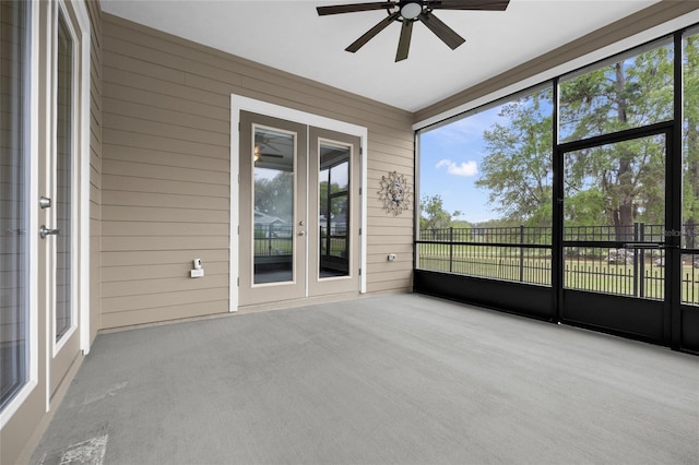 unfurnished sunroom with french doors, a ceiling fan, and a wealth of natural light