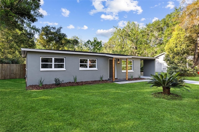 view of front of home featuring stucco siding, fence, and a front lawn