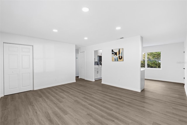 unfurnished living room with visible vents, baseboards, recessed lighting, and wood finished floors
