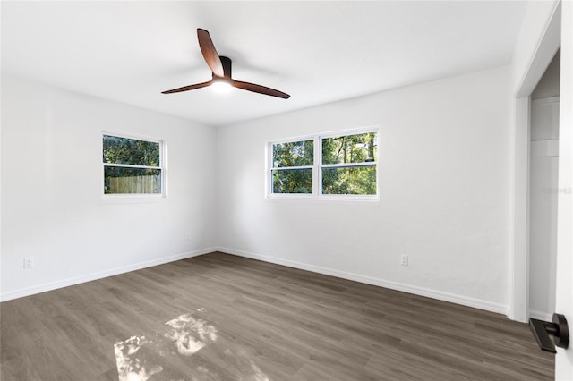 empty room featuring a ceiling fan, baseboards, and wood finished floors