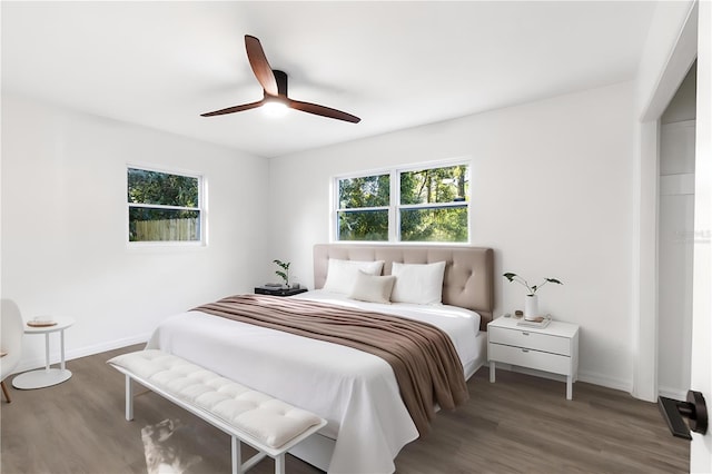 bedroom featuring baseboards, wood finished floors, and a ceiling fan