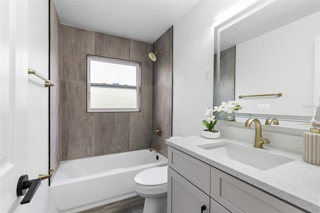 bathroom featuring toilet, vanity, bathing tub / shower combination, and wood finished floors