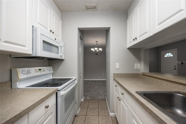 501 SW 75th St Unit E3, Gainesville, FL 32607 - kitchen with white appliances, white cabinets, light tile patterned floors, and a sink